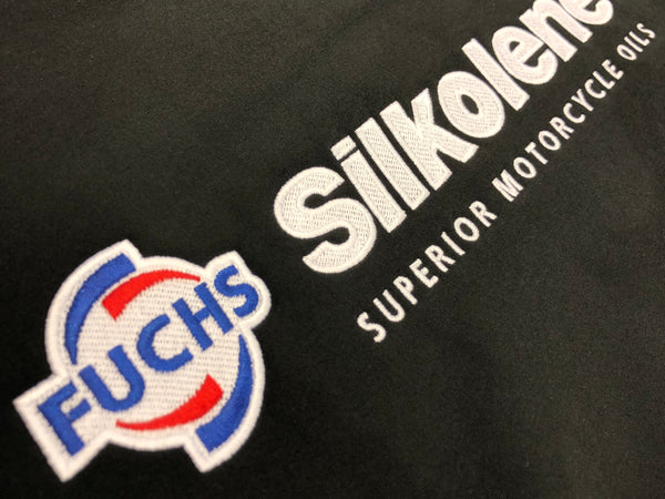 FUCHS and Silkolene logos embroidered together on a black work jacket, showing multi-brand embroidery for Fuchs Lubricants UK