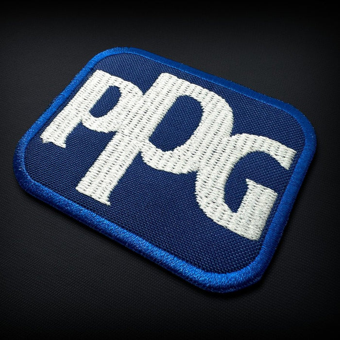 Embroidered patch badge with dense stitched lettering and a merrowed border