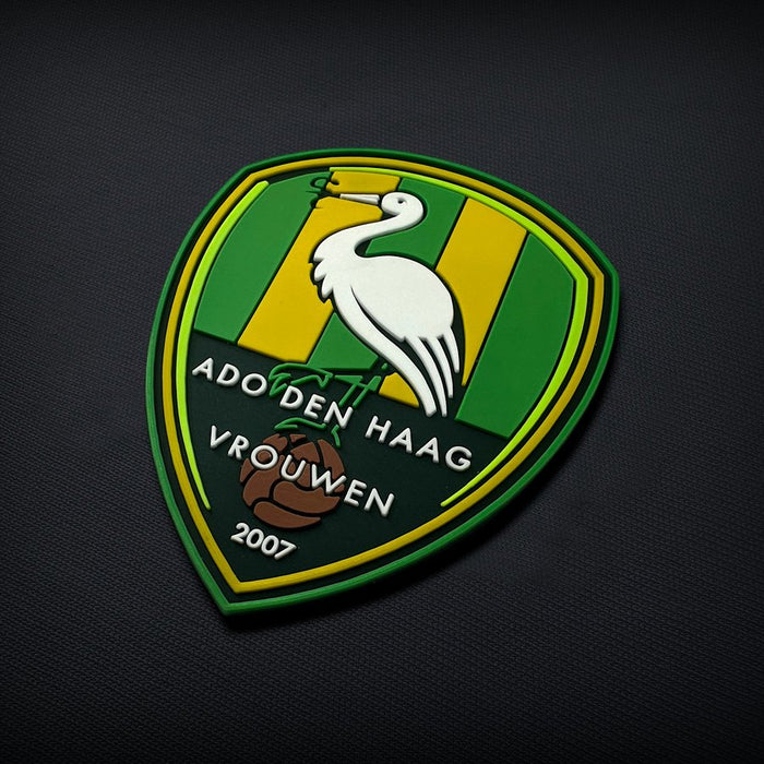 Thick moulded rubber club crest with bold raised lettering and solid colour blocks